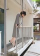 A woman leaning against a railing on a sidewalk.