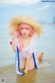 A woman in a straw hat is sitting in the water.