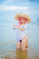 A woman in a straw hat is standing in the water.