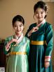 A couple of young women dressed in traditional Korean clothing.