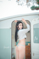 A woman in a blue bikini standing in front of a trailer.