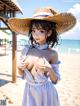 A woman in a straw hat is posing on the beach.