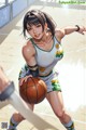 A woman holding a basketball on a basketball court.