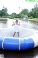 A woman in a white dress standing on a trampoline.