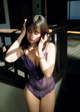 A woman in a purple lingerie talking on a cell phone.