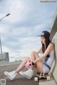 A woman sitting on a skateboard with her legs crossed.